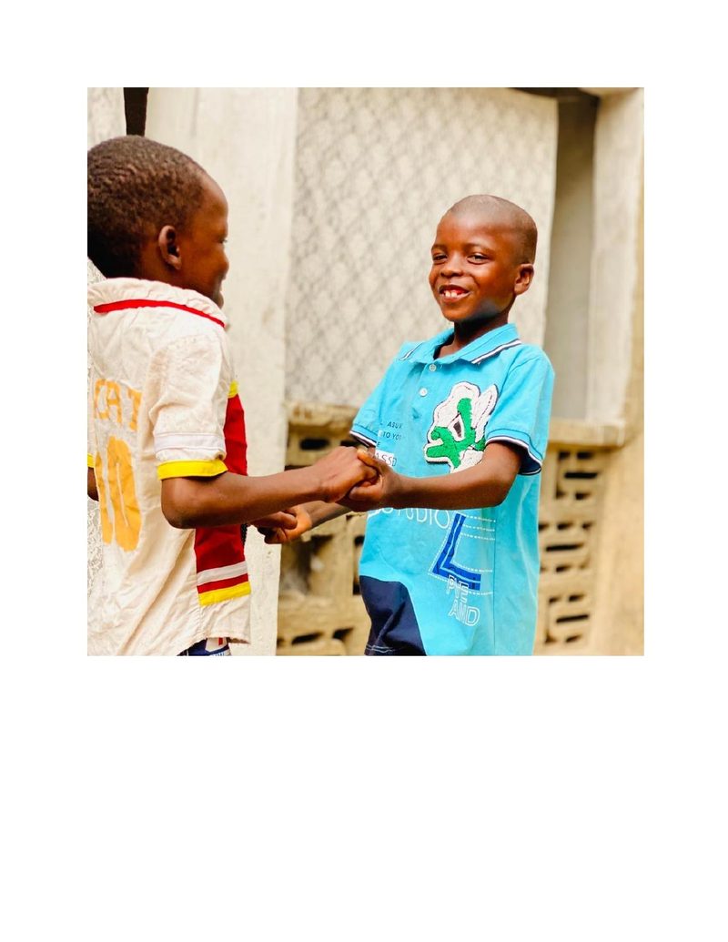 Mohammed Ali shaking hands playfully with a friend outdoors, both smiling