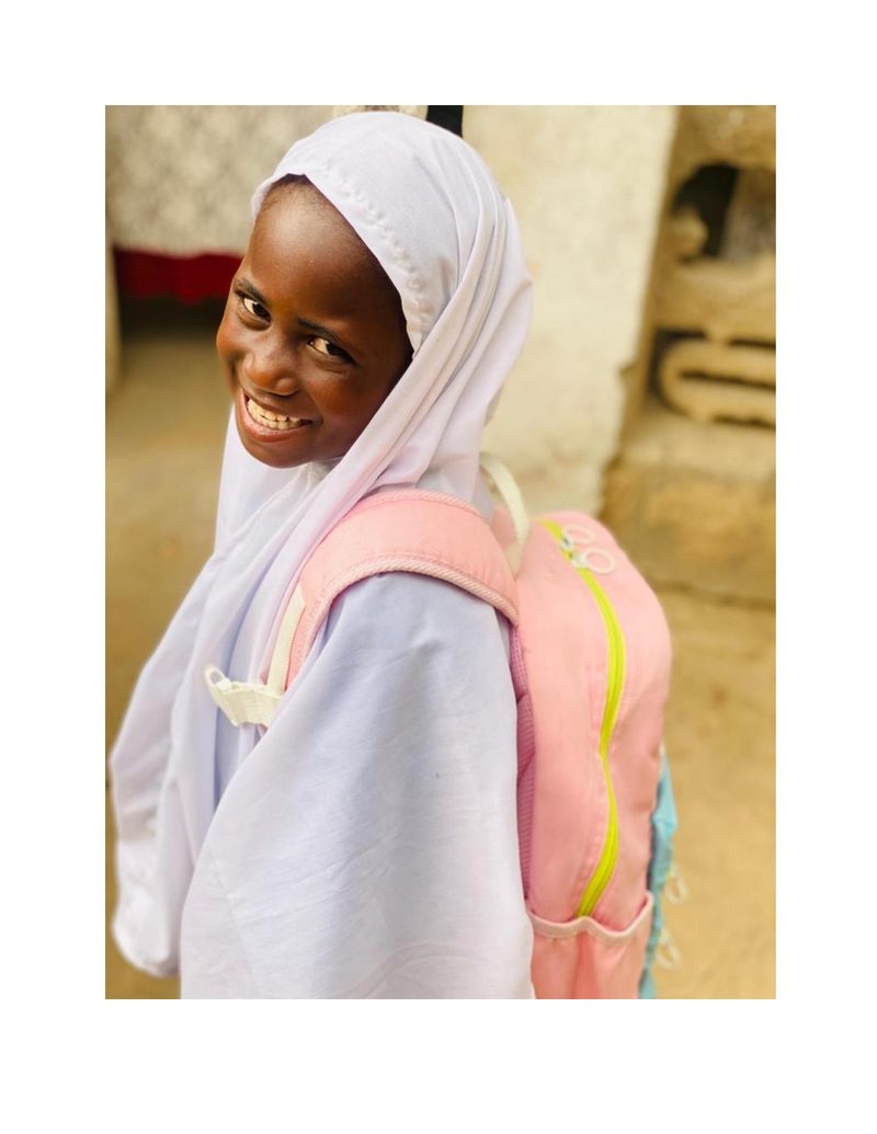 Fatima Mohammed smiling over her shoulder with her pink backpack