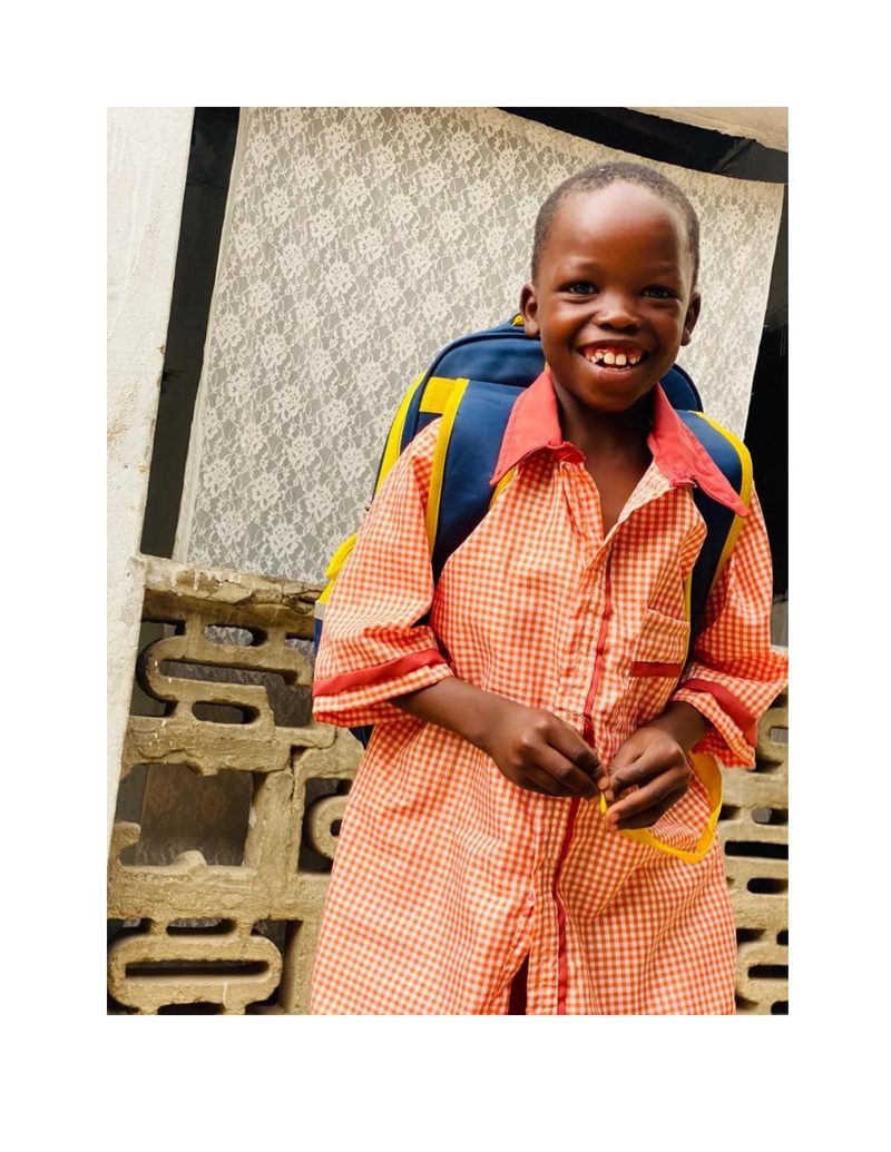 Ahmad Usman laughing in his new orange school uniform